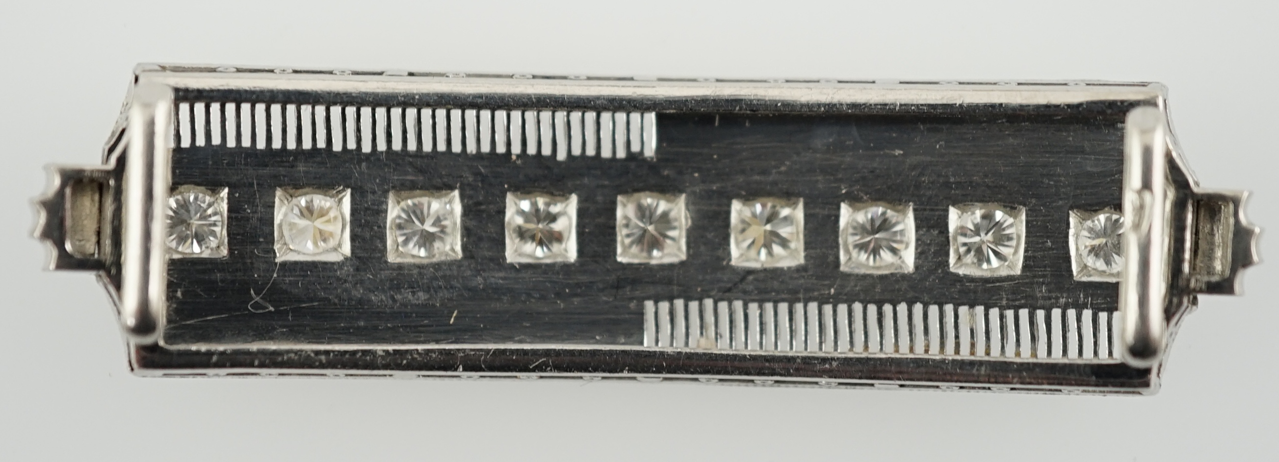 A platinum and eight stone diamond set concave clasp/attachment